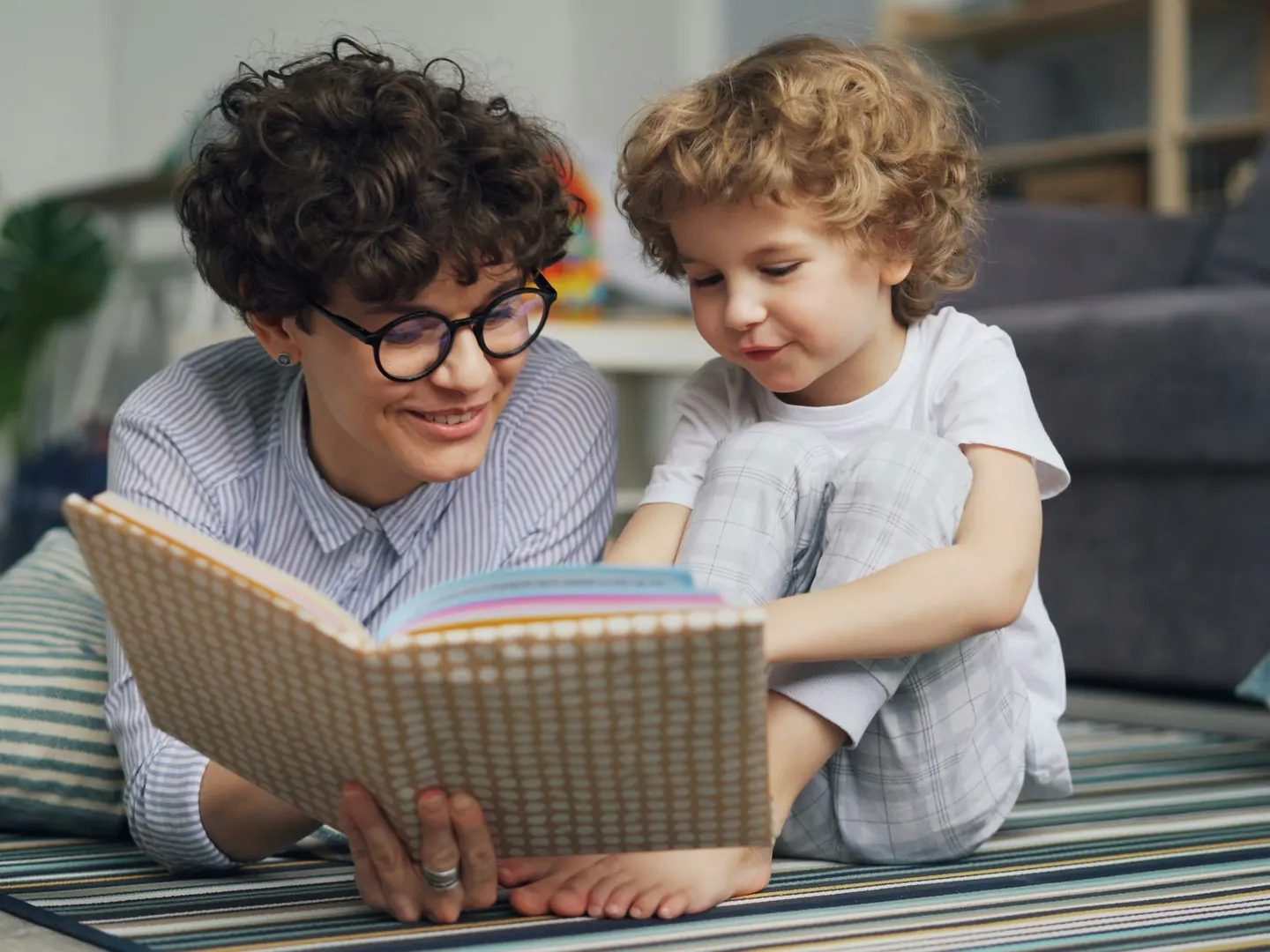 A woman and a girl reading together on the floor