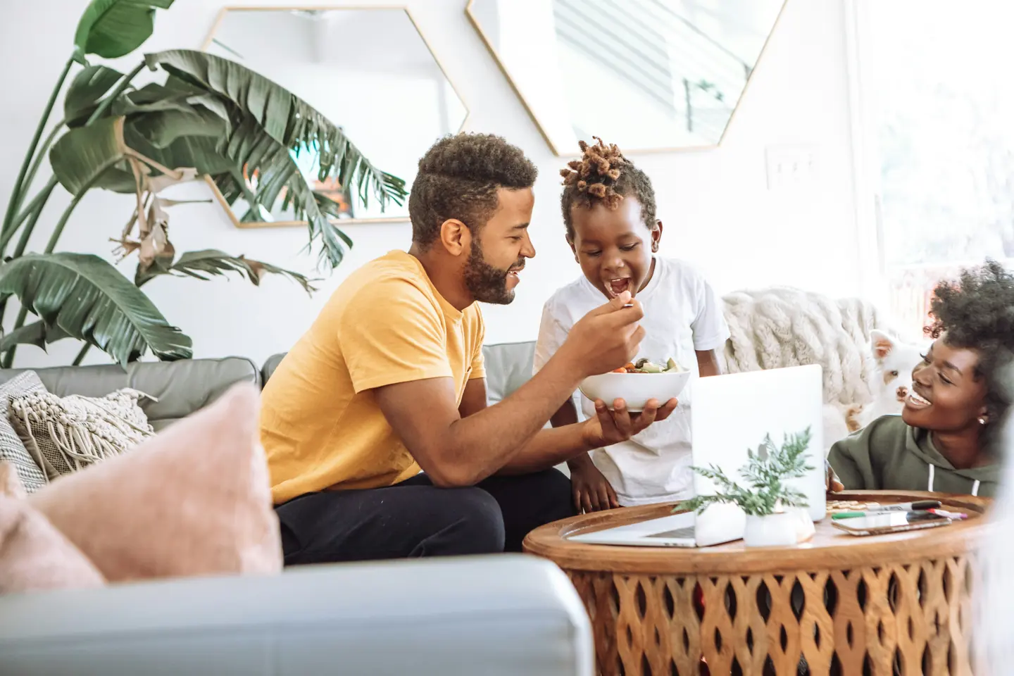 A family sharing a snack in a bright living room