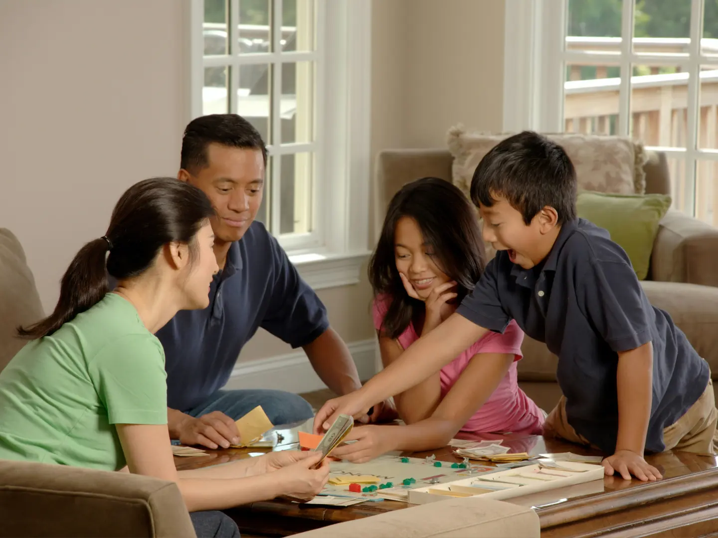 Adults and children playing a board game together at home
